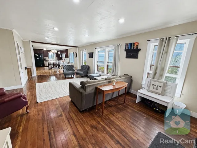 Wood-finish flooring throughout, recessed lighting, and multiple windows with white trim