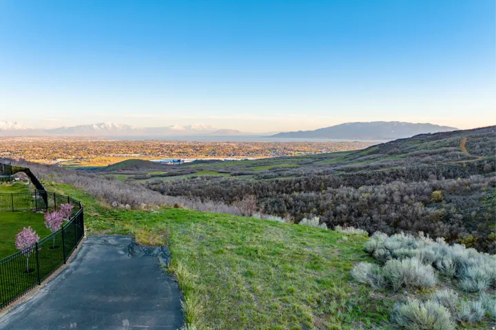 Expansive landscape featuring distant mountains, a sprawling valley, and varied terrain with natural vegetation