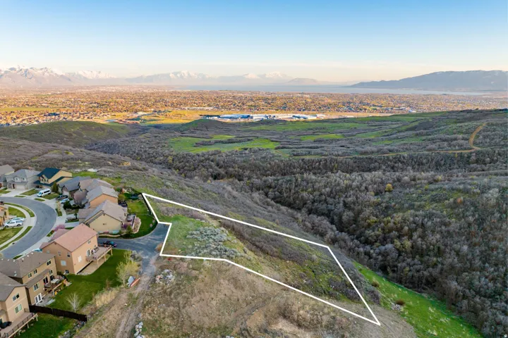 Expansive lot outlined against a backdrop of distant mountains and a valley with a body of water