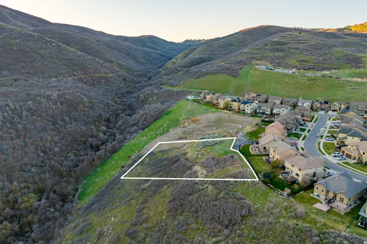 Expansive land parcel featuring natural terrain and proximity to established residential areas