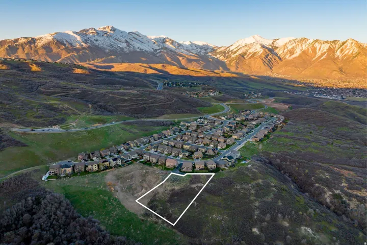 Expansive land parcel with surrounding residential development and mountainous terrain