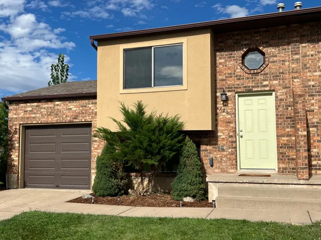 Brick and stucco exterior with an attached garage, a panel-style front door, and an octagonal window detail