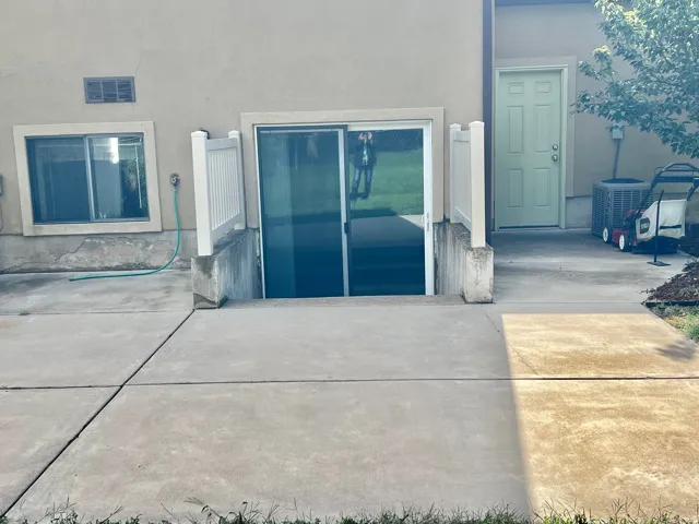 Stucco exterior with a basement walk-out, sliding glass door, and an additional exterior door