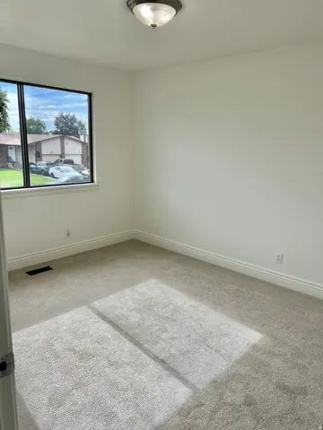 Neutral tone wall finishes, gray carpet flooring, white trim details, and a flush mount ceiling light fixture