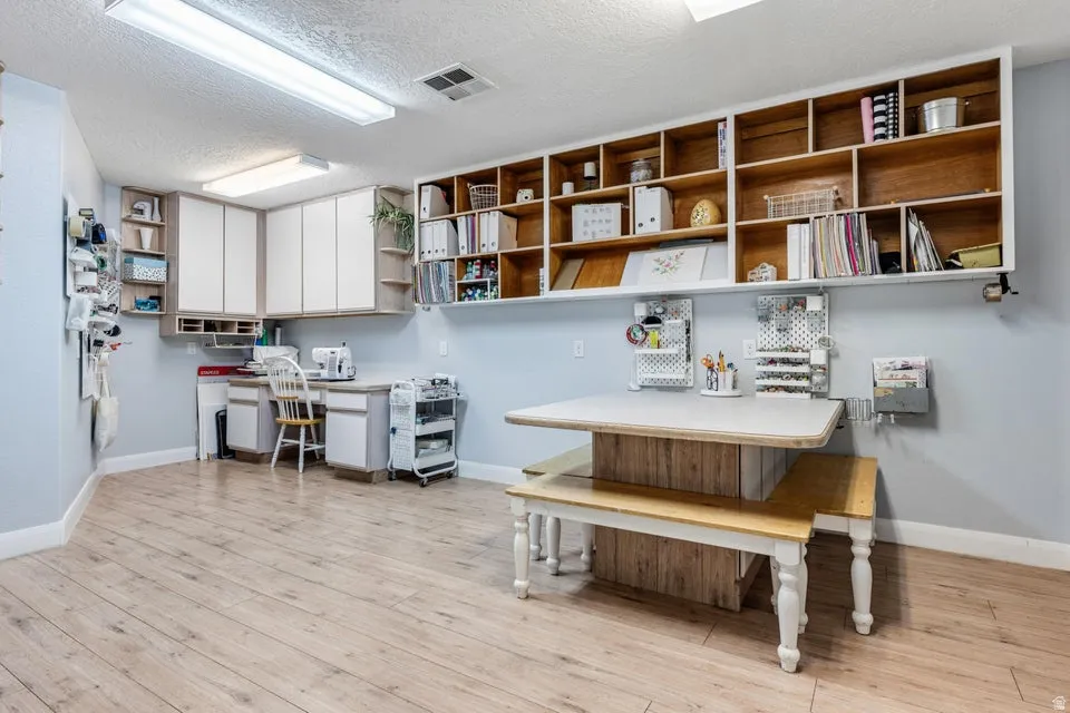 Wood-finish flooring with extensive built-in shelving, white cabinetry, and recessed lighting