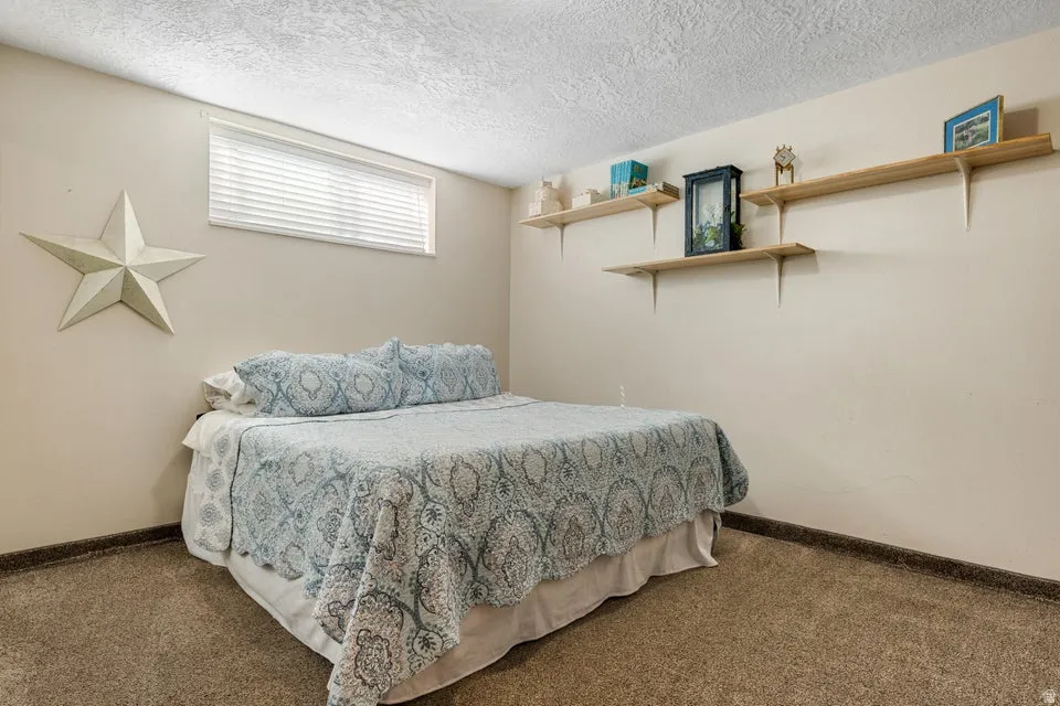 Built-in shelving units, textured ceiling, and a horizontal window with blinds