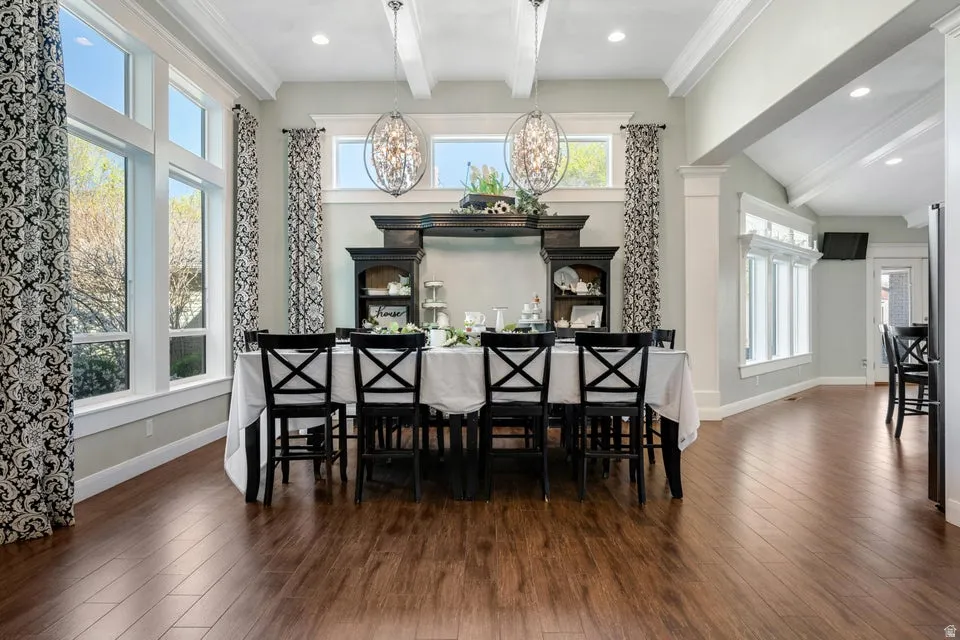 Expansive windows, wood-finish flooring, high vaulted ceilings, recessed lighting, and decorative pendant light fixtures