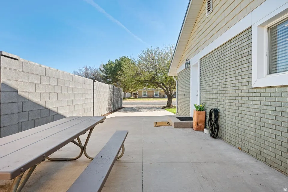 Paved concrete patio area with a block privacy wall