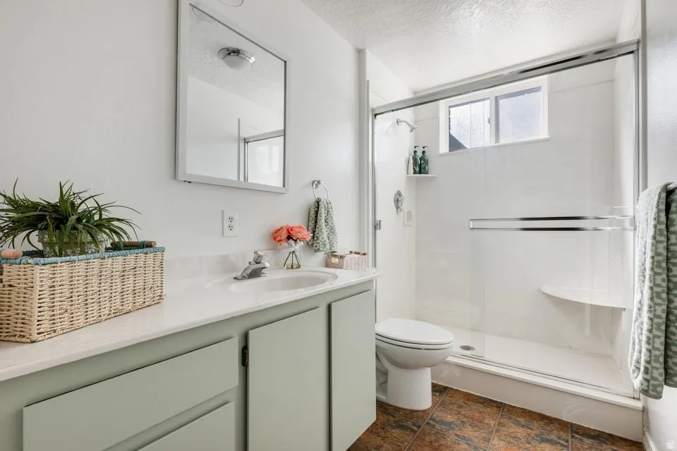 Bathroom featuring a single vanity with light green cabinetry, a white countertop, and an integrated sink
