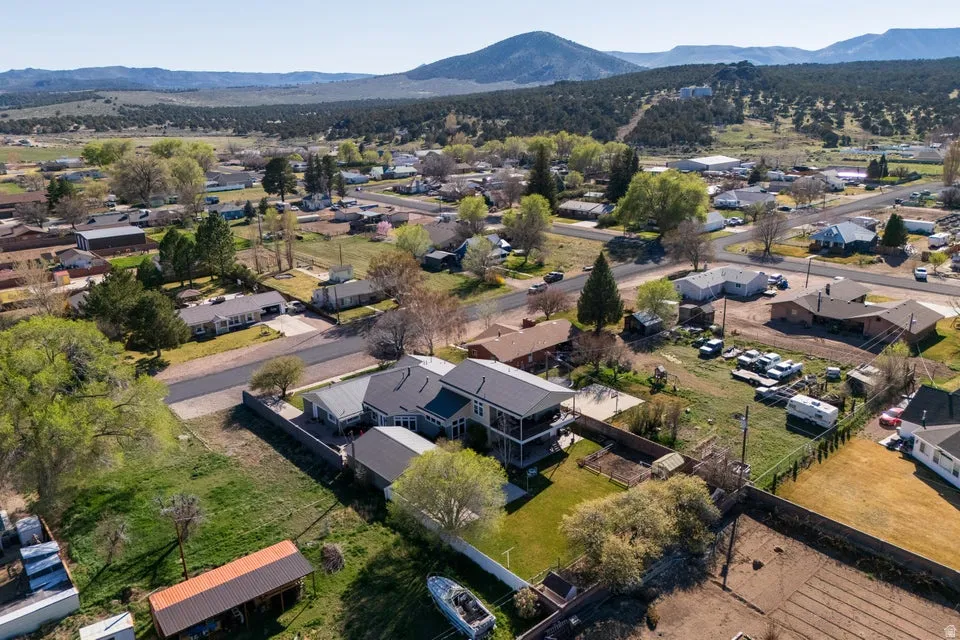 Expansive property featuring a multi-story residence with a two-tier balcony, a detached garage, and a large grassy yard