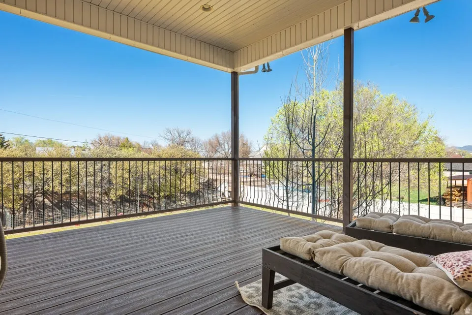 Covered outdoor deck with composite decking, dark metal railings, and integrated overhead lighting