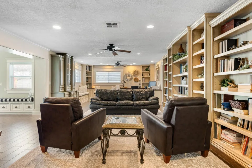 Recessed lighting, ceiling fans, wood-finish flooring, built-in shelving, and a window seat with integrated storage
