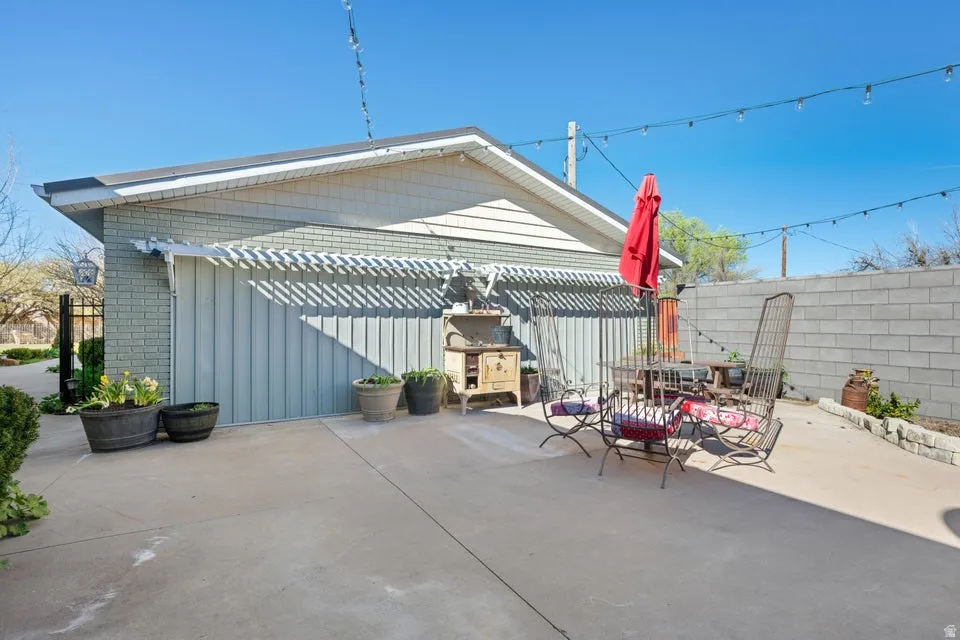 Concrete patio with a privacy block wall and string lighting