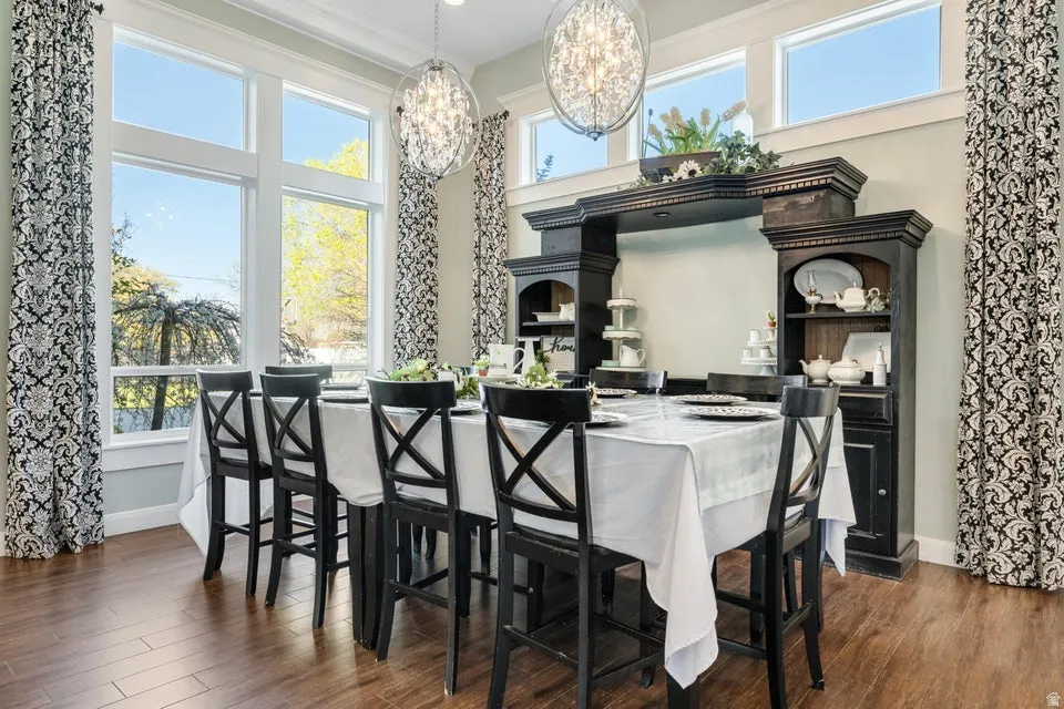 Expansive window wall, wood-finish flooring, built-in shelving, decorative overhead lighting