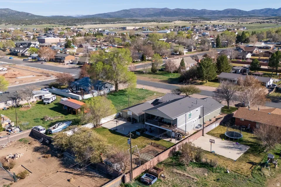 Two-story residence with a covered balcony, fenced yard, and a basketball court