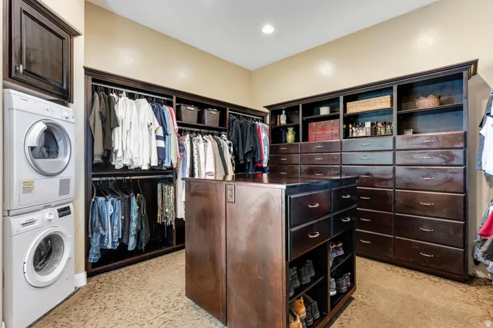 Custom closet system with dark wood-finish cabinetry, extensive shelving, and multiple drawers