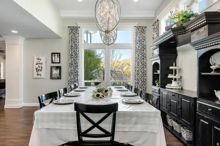 Recessed lighting, wood-finish flooring, built-in cabinetry, large windows, and decorative crown molding