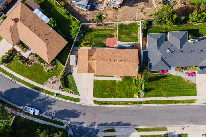 Expansive lot featuring mature landscaping, a paved driveway, and a well-maintained lawn