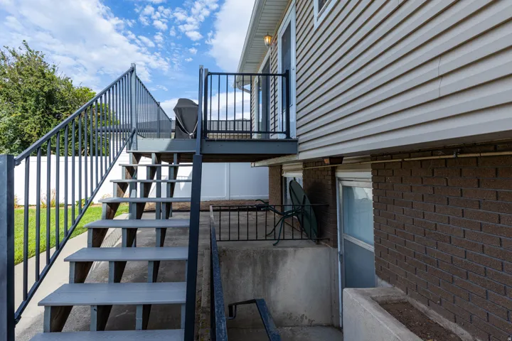 Exterior stairway with metal railings to an upper-level balcony