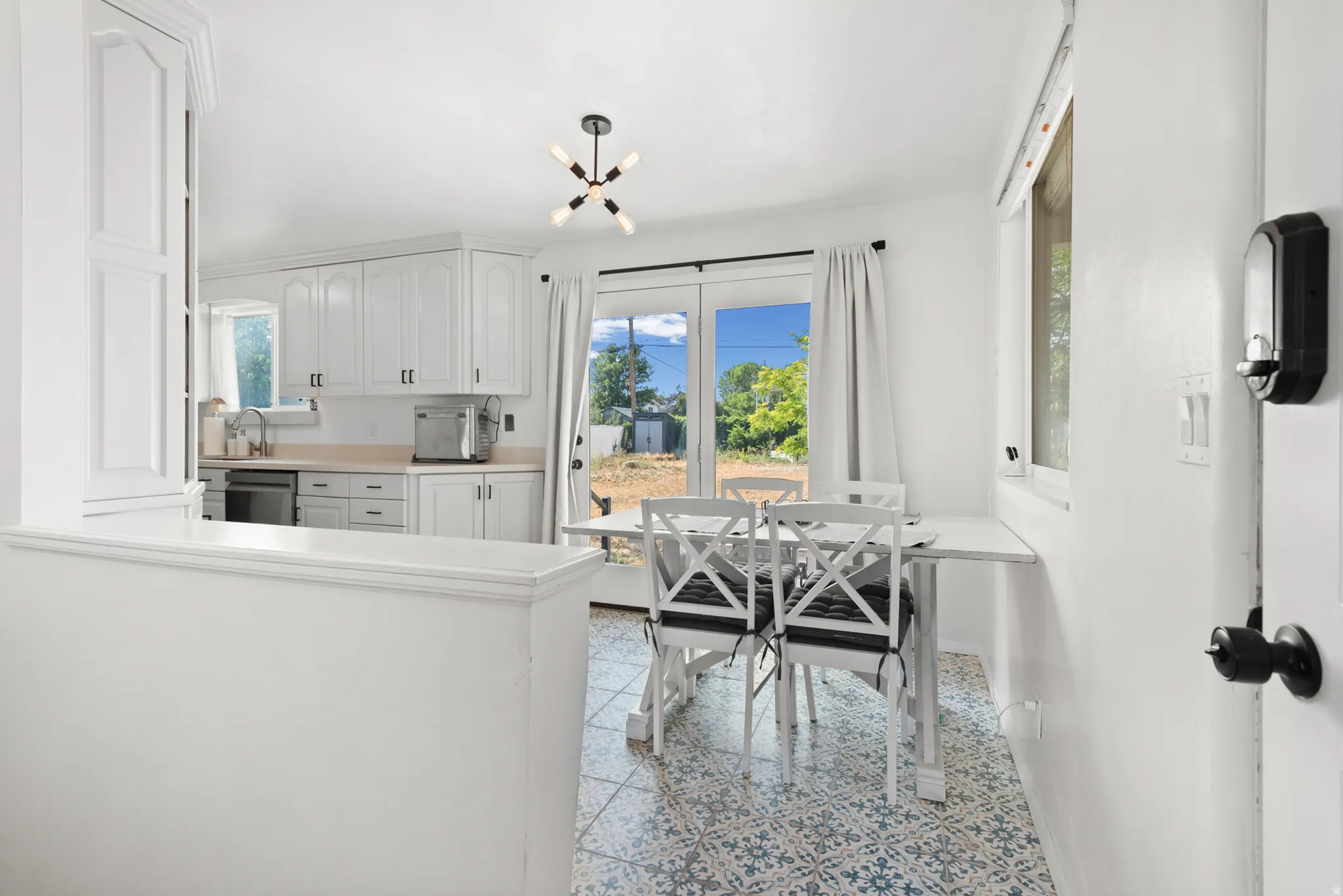 White cabinetry with matte black hardware, light-toned countertops, and a built-in oven