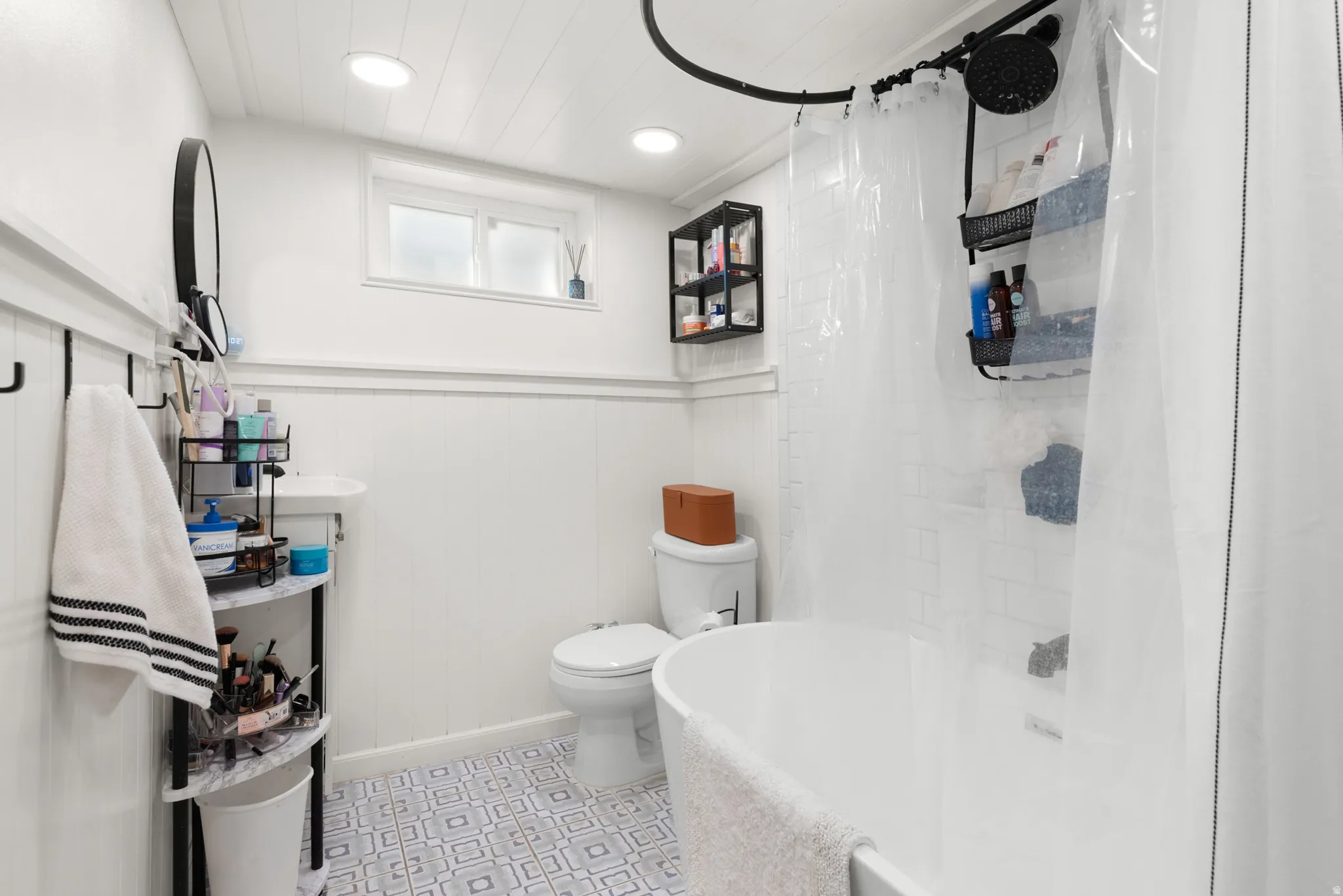 Bathroom with wainscoting, recessed lighting, a window, pedestal sink, and patterned floor tiles