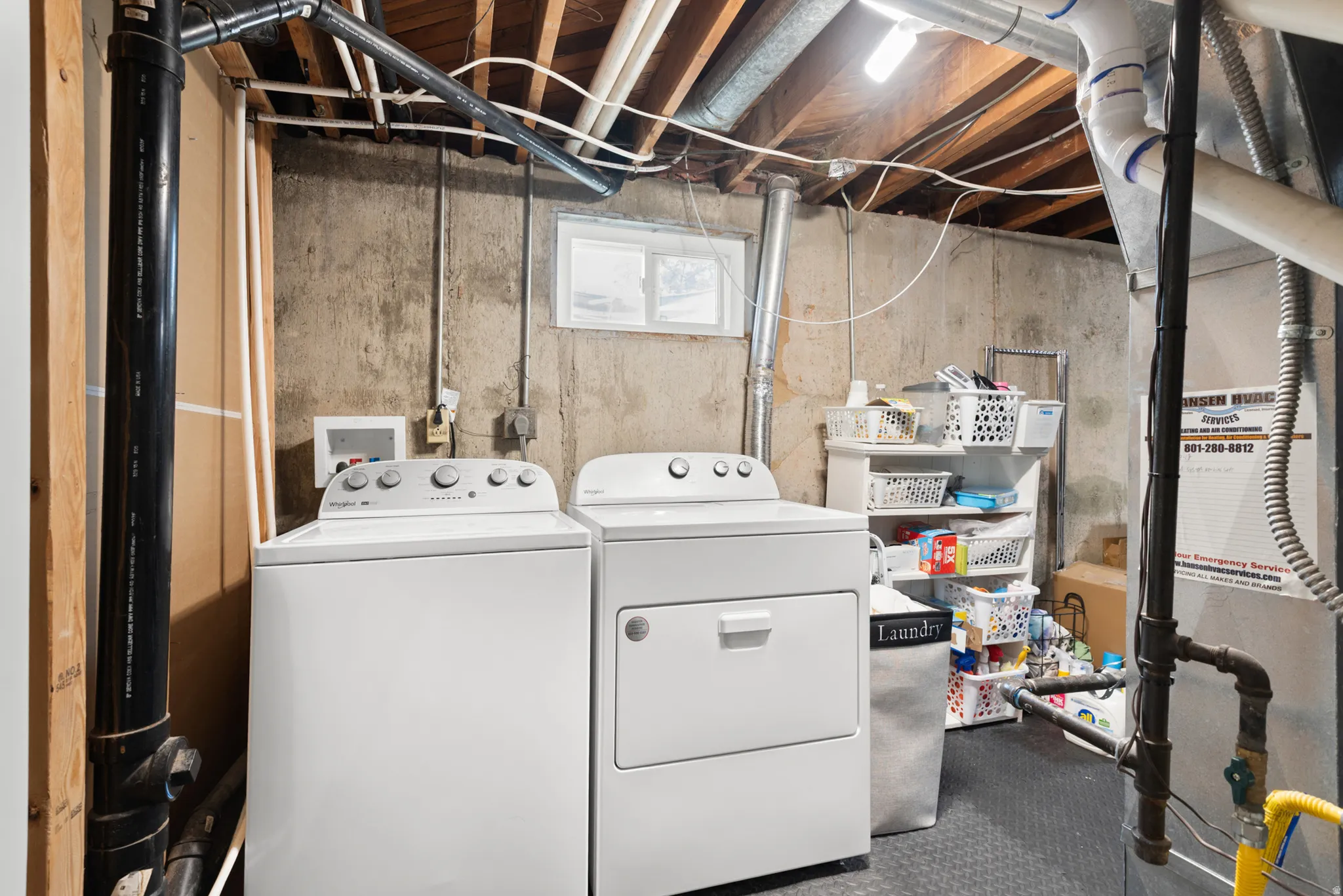 Concrete foundation walls, exposed ceiling joists, and a window for natural light