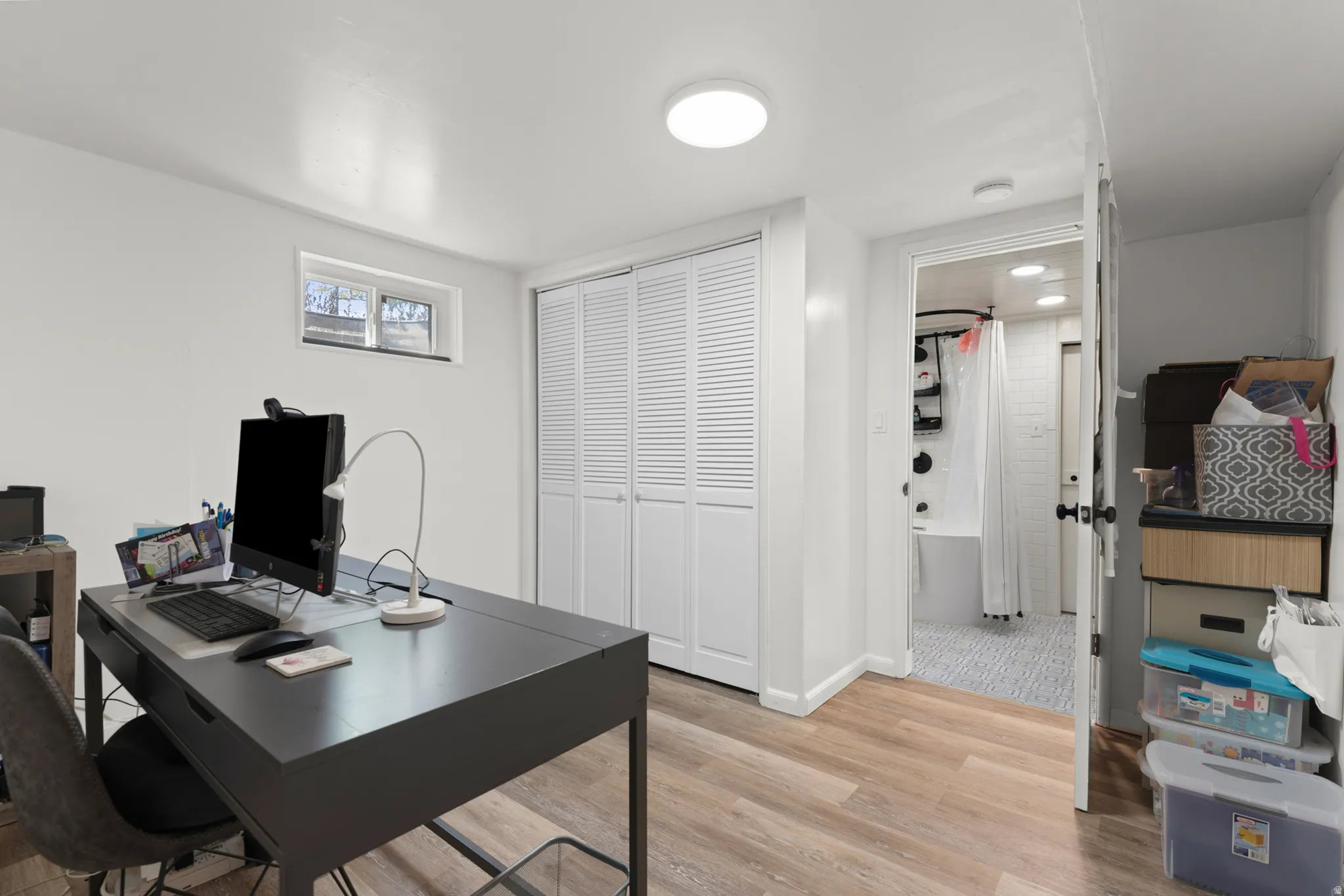 Wood-finish flooring, white walls, and a window