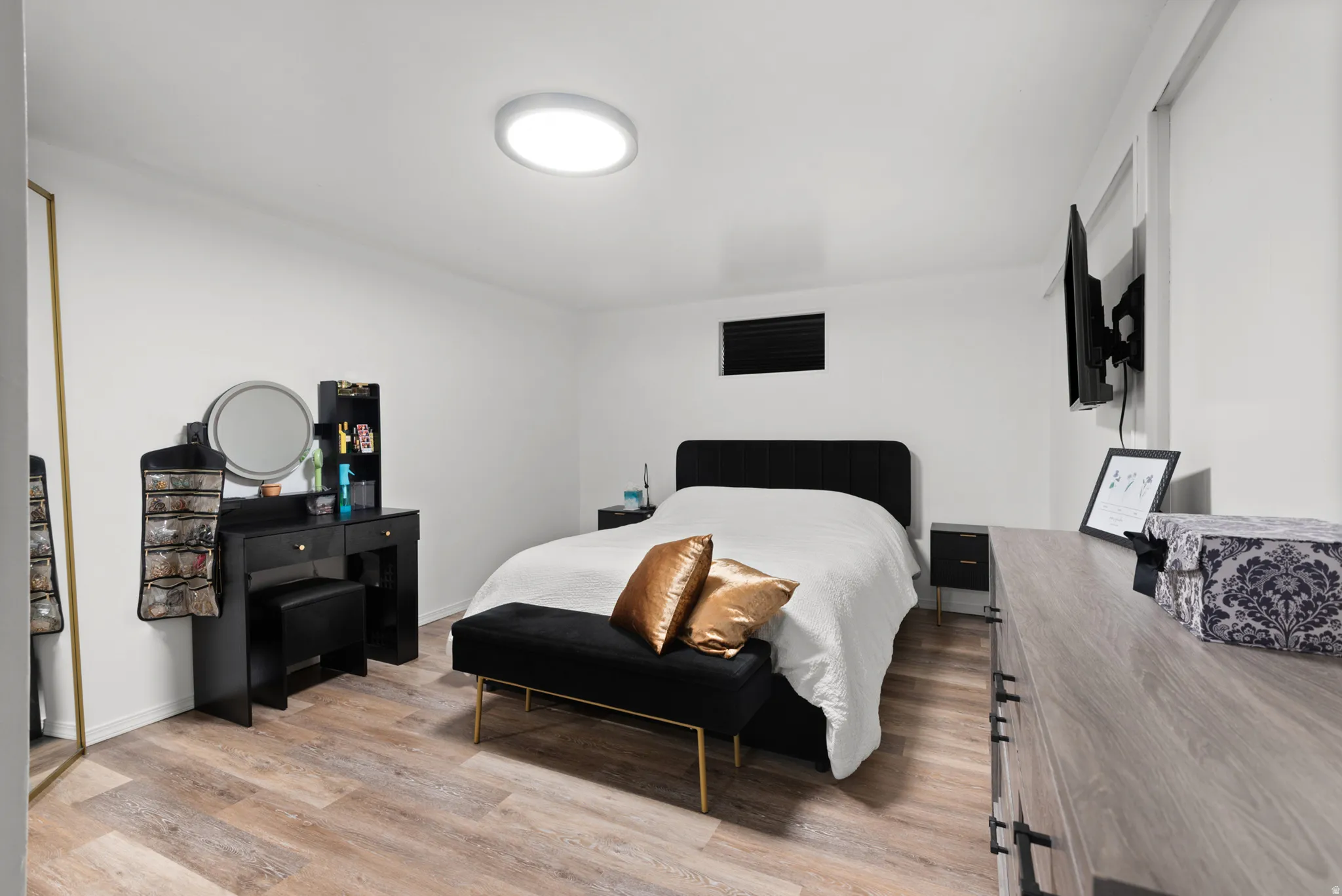 Wood-finish flooring, white walls, and a contemporary ceiling light fixture