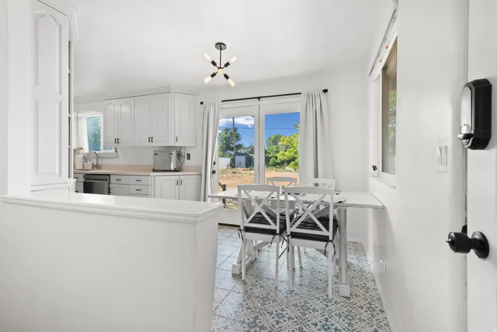 White cabinetry with matte black hardware, light-toned countertops, and a built-in oven