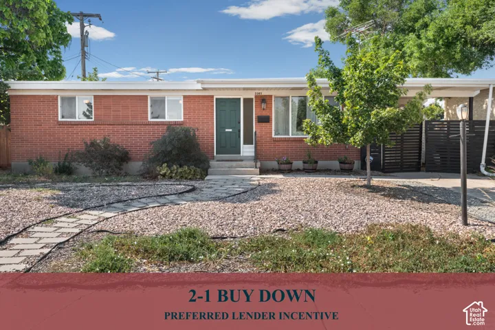 Mid-century ranch exterior featuring red brick masonry, a covered carport, horizontal privacy fencing, and stone walkway