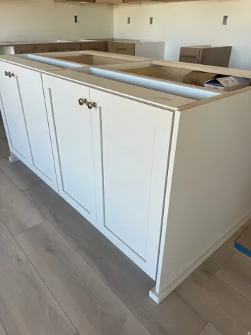 White shaker-style cabinetry with brass hardware