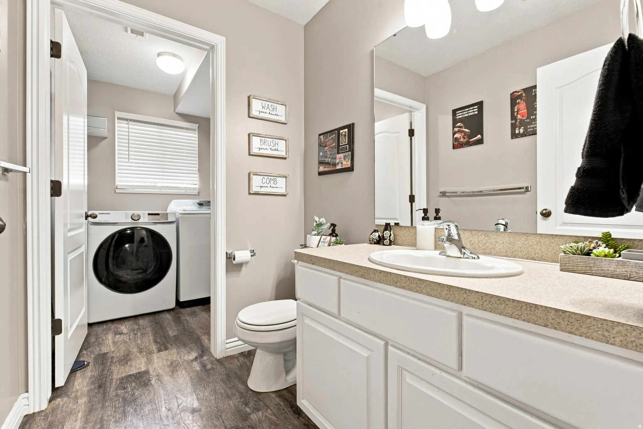 Single vanity with an integrated sink, polished chrome faucet, and expansive mirror