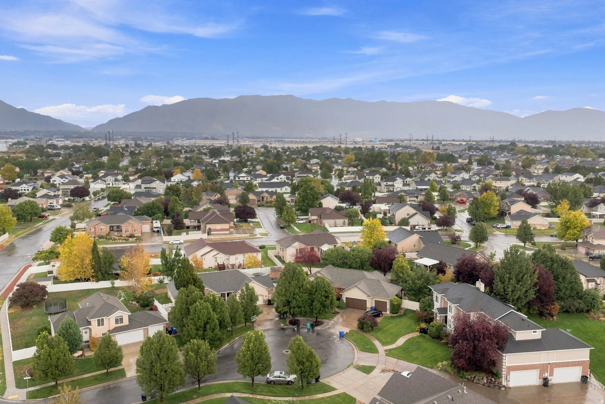 Residential neighborhood featuring paved streets and established landscaping, with a prominent mountain backdrop
