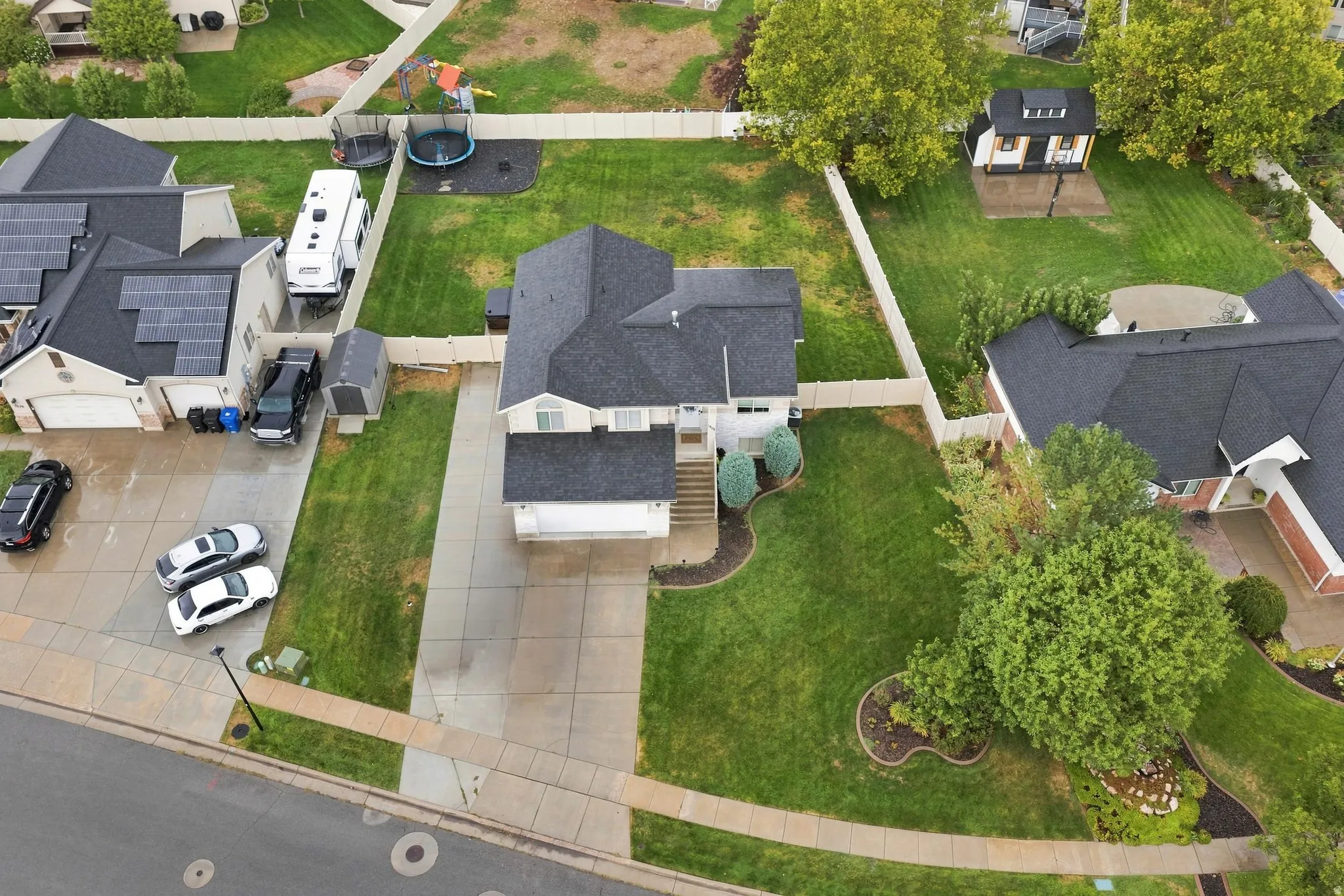 Two-story residence with an attached garage, paved driveway, and established landscaping