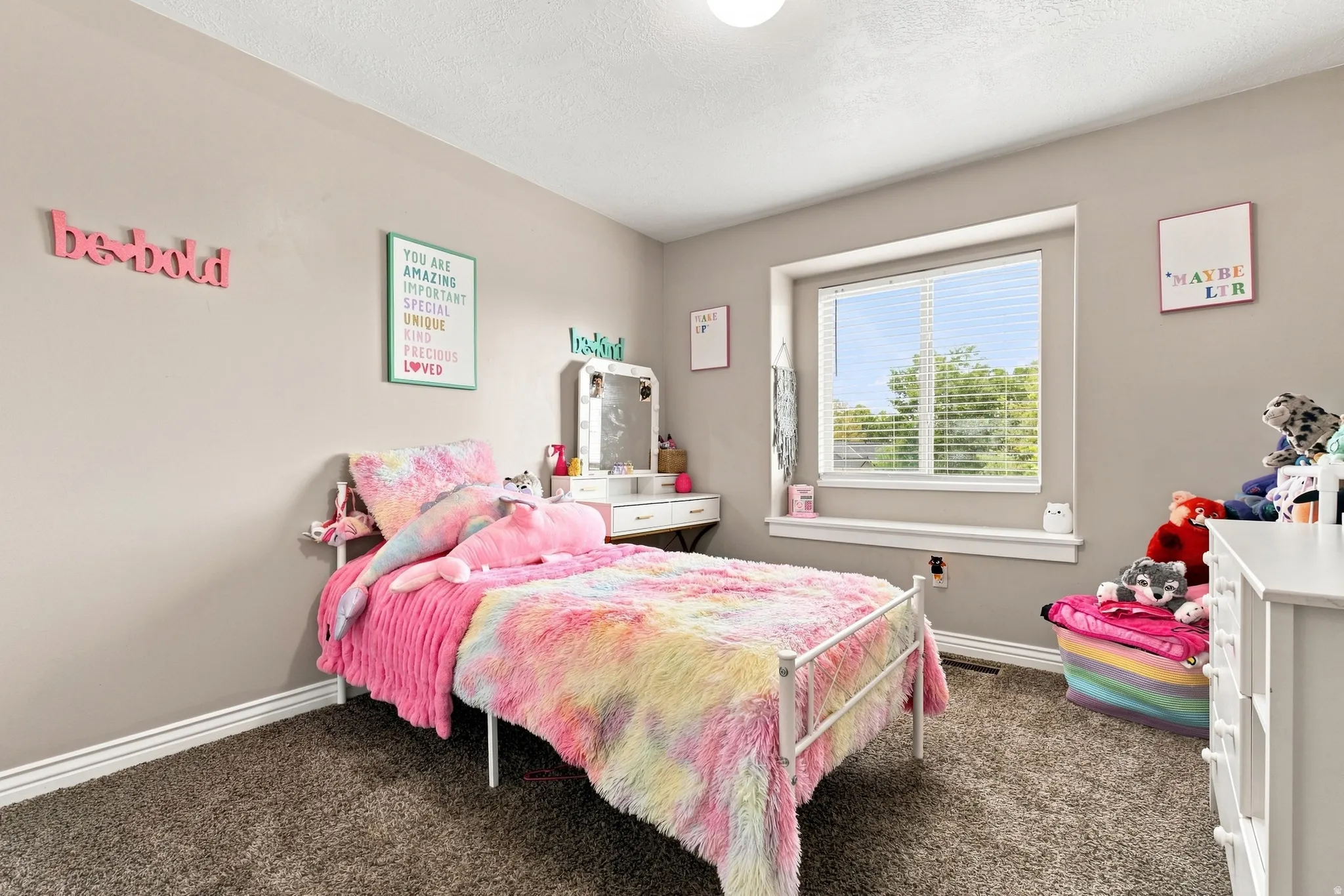 Plush carpet flooring, neutral painted walls, and a large window with blinds