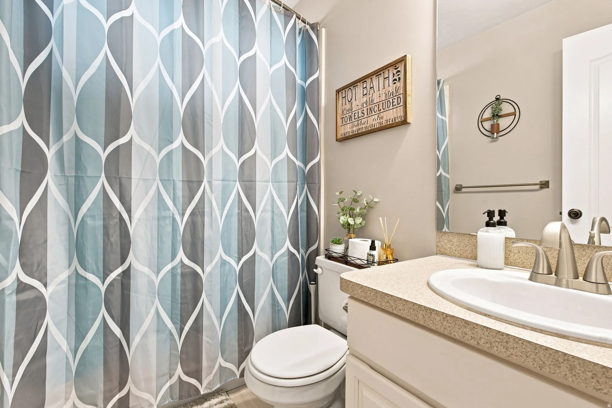 Bathroom featuring a vanity with an integrated sink, dual-handle faucet, and framed mirror