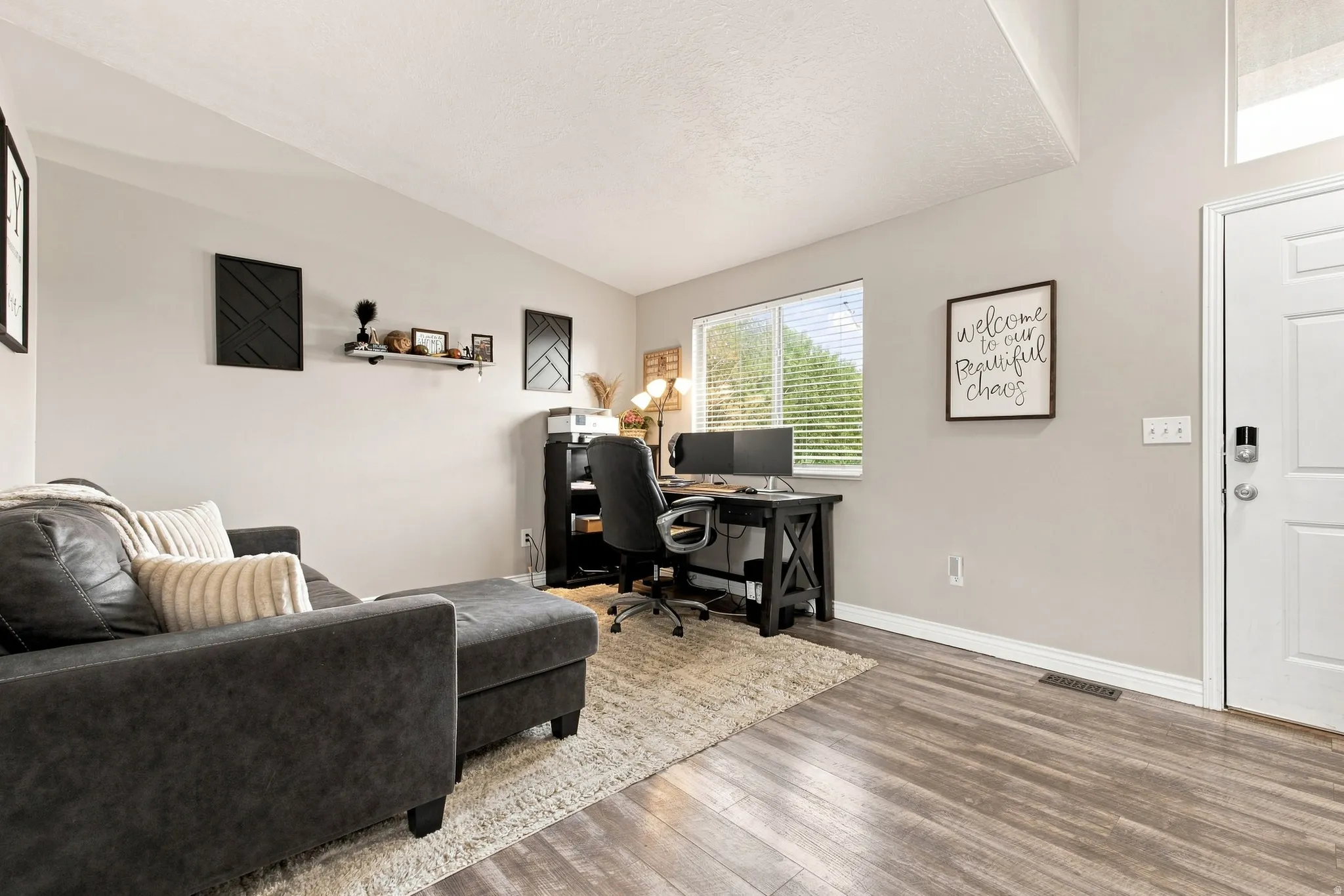 Wood-finish flooring, light gray wall paint, and a white paneled door