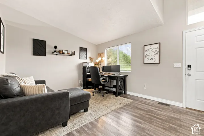 Wood-finish flooring, light gray wall paint, and a white paneled door
