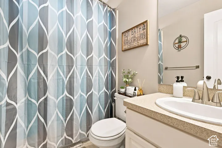Bathroom featuring a vanity with an integrated sink, dual-handle faucet, and framed mirror