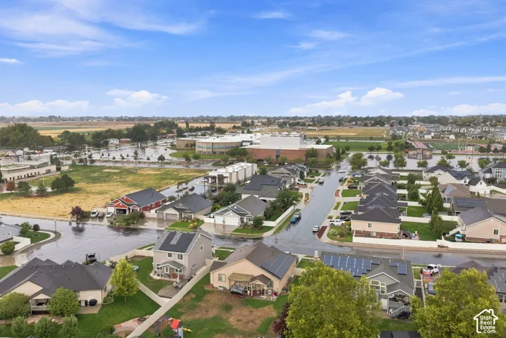 Residential neighborhood with multiple properties featuring solar panels, paved streets, and landscaped yards