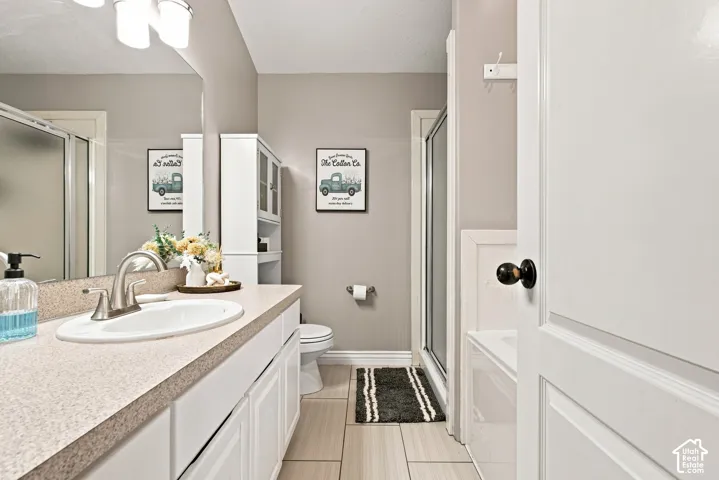 Bathroom featuring a vanity with an integrated sink, a large mirror, a built-in storage cabinet, a shower enclosure, and a tub