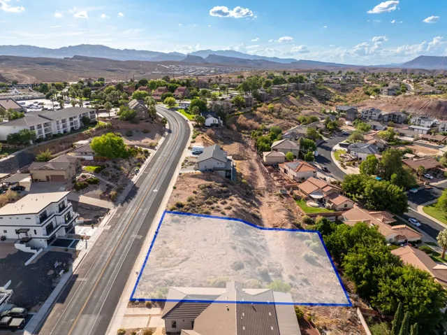 Expansive vacant lot featuring a cleared building site, direct road frontage, and surrounding residential properties