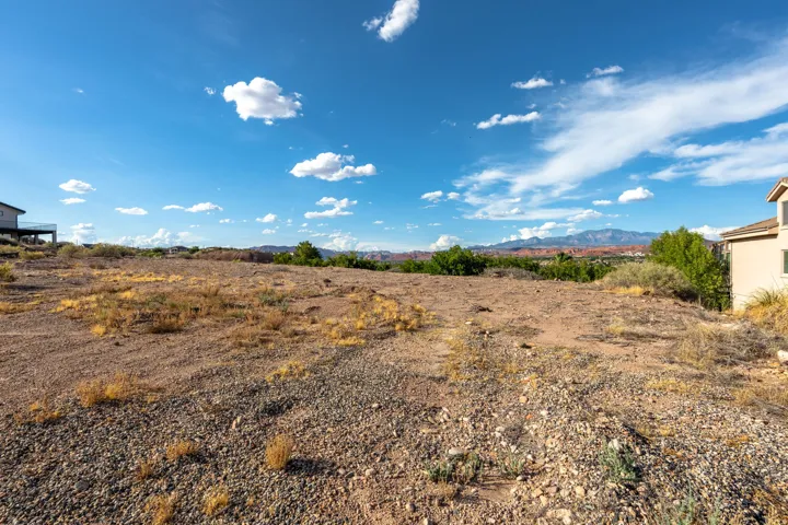 Expansive vacant land featuring a natural desert landscape and distant mountain ranges