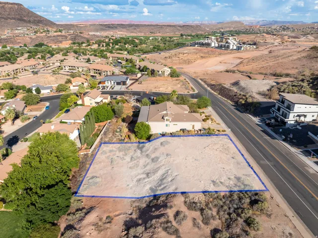 Expansive desert lot featuring a clear, level building area bordered by natural landscaping