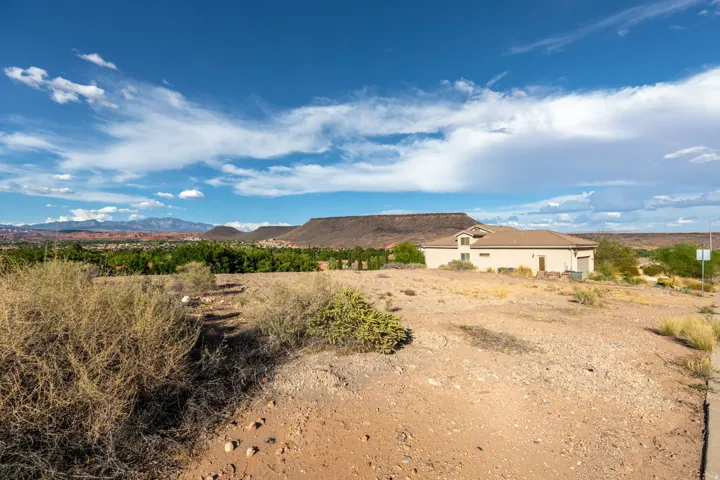Southwestern-style stucco residence with an attached garage, situated on a sloped lot