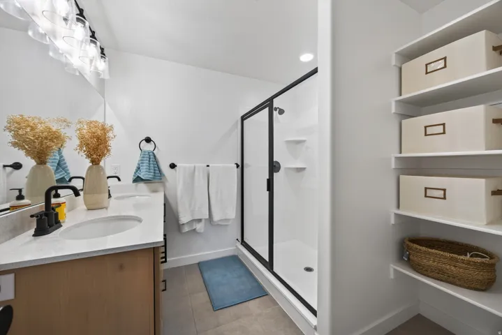 Second floor owners bathroom with spa-inspired primary bathroom featuring a floating vanity with rectangular vessel sink, quartz countertop, and matte black faucet.