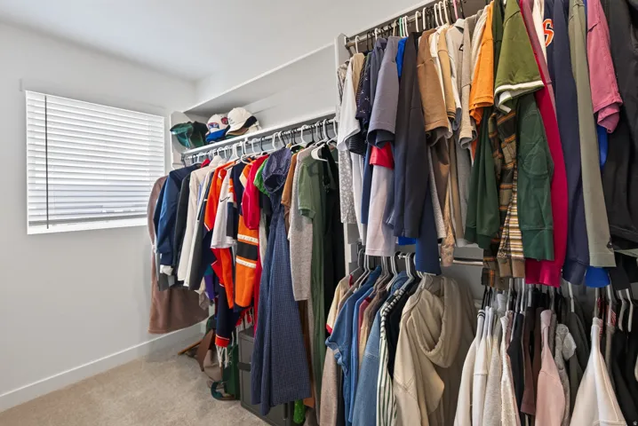 Second floor owners closet with space saver shelving and rods. Window for natural light.