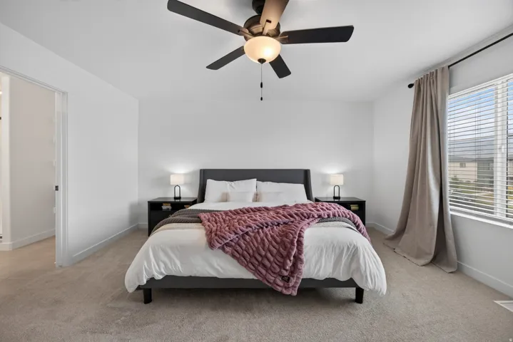 Second floor owners bedroom with white walls and light-toned carpeting create a bright interior.