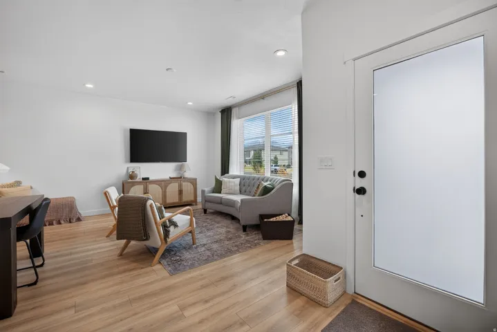 Main floor entry with recessed lighting, wood-finish flooring, and a window with blinds.