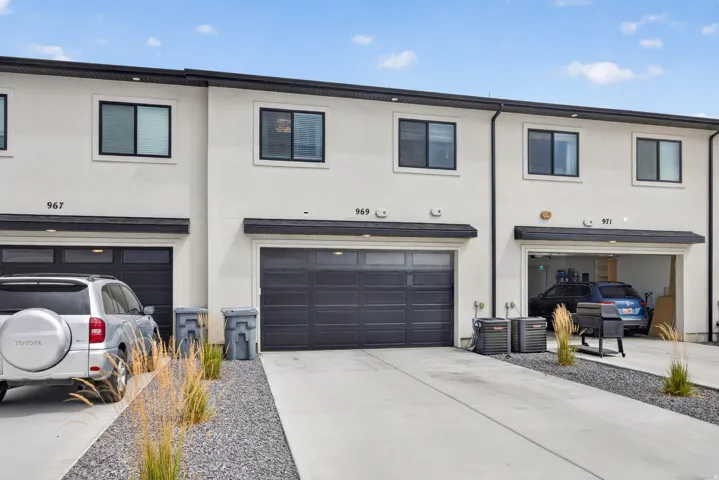 Lane load garage with modern stucco exterior with black-framed windows and dark garage doors.